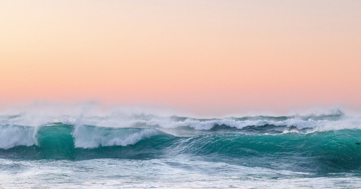 Waves breaking along the shore at dawn
