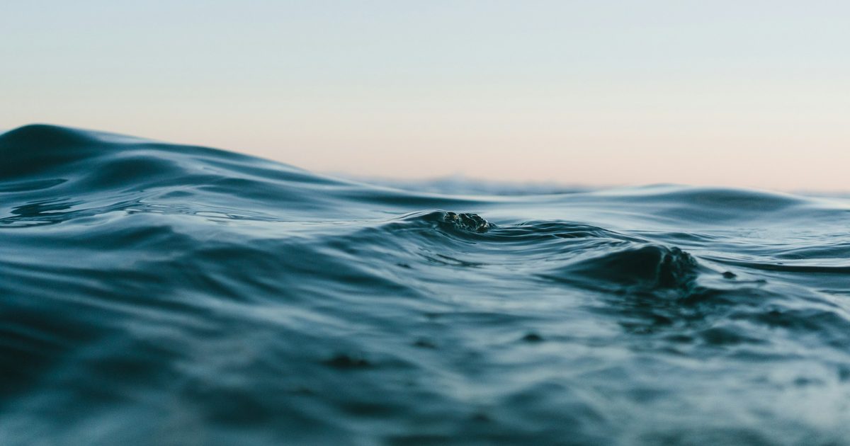 A low swell rolling across the ocean at dusk